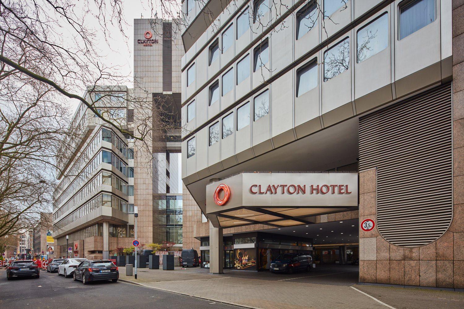 Außenansicht des Clayton Hotel Düsseldorf mit Hotelbeschilderung und überdachter Zufahrt.